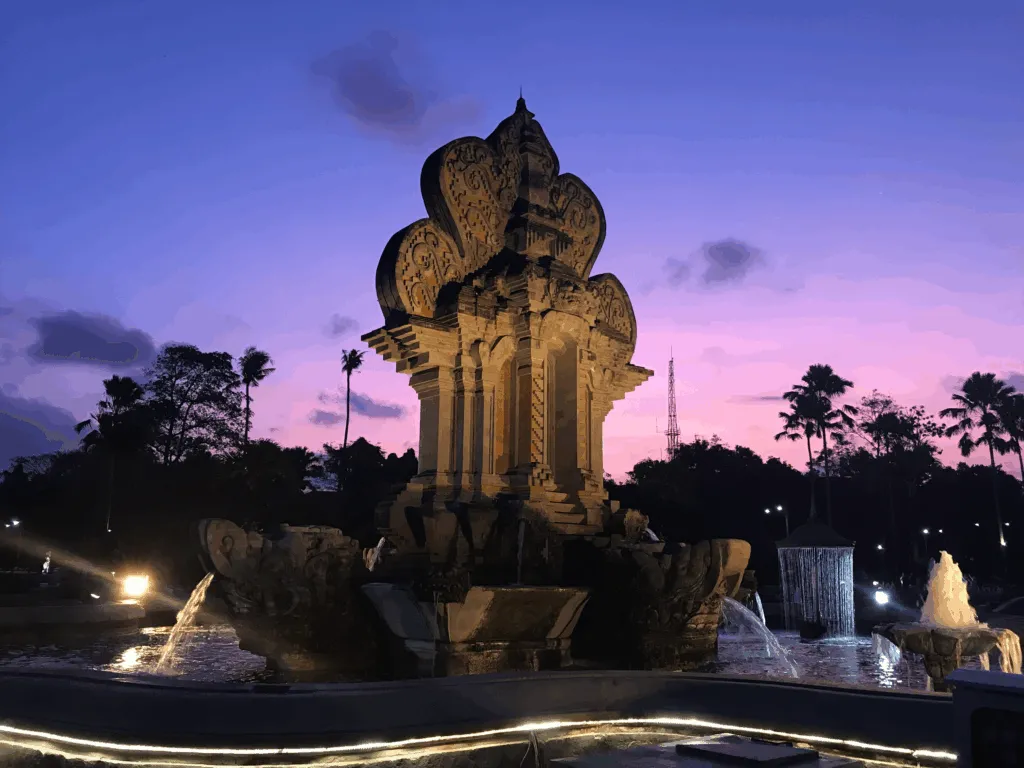 The Best Time to Visit Bali (and Why) Dramatic sunset over intricate temple with fountains.