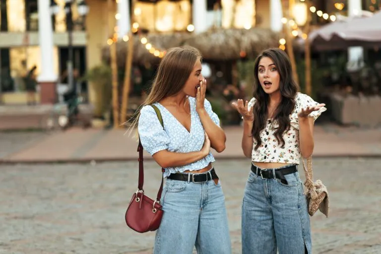 Avoiding Tourist Traps in Bali: 3 Popular Spots & Their Secret Alternatives Curly brunette woman in white floral top and jeans talks to her friend and tells her secrets. Blond