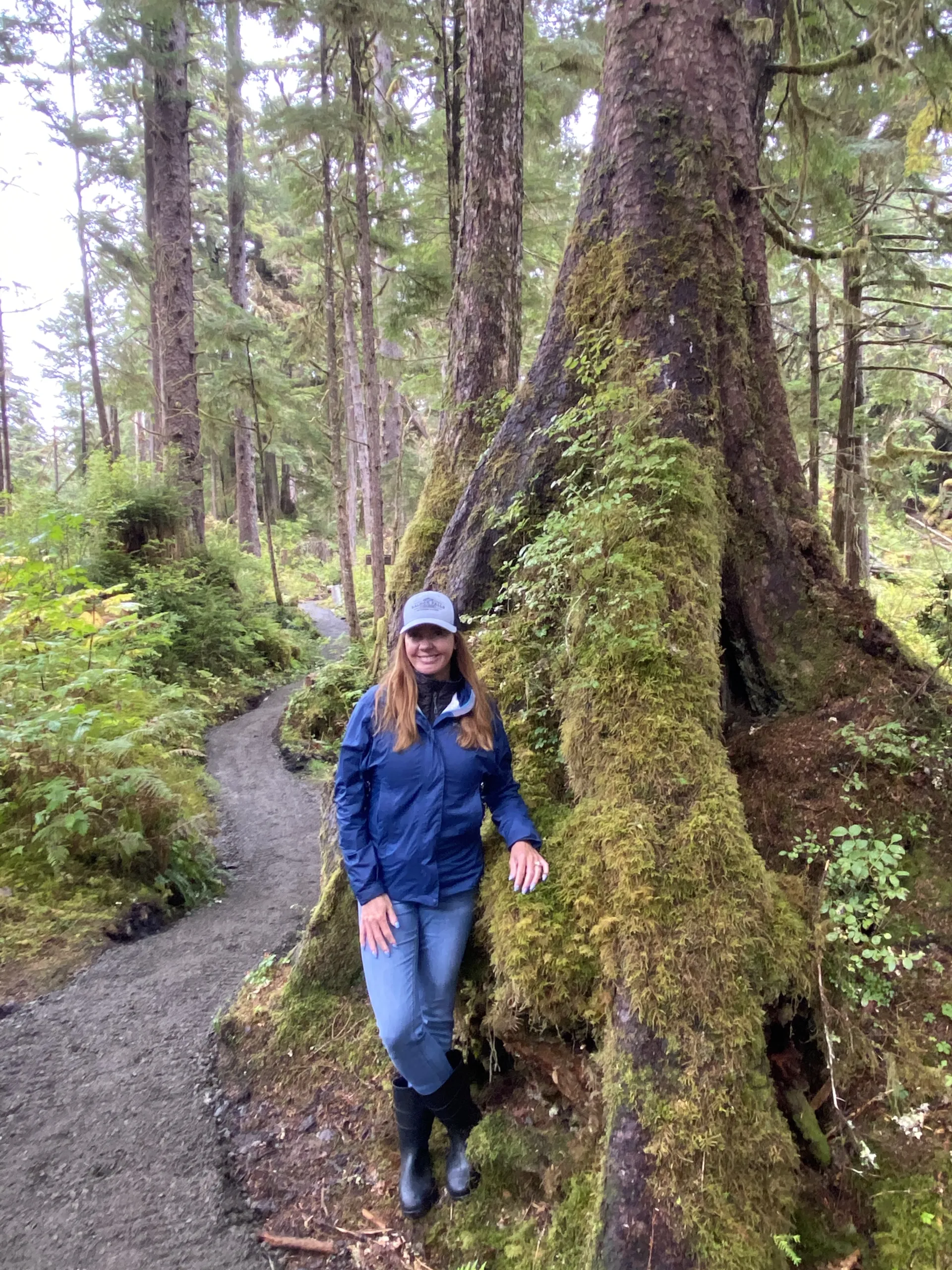 Person standing by tree on forest trail