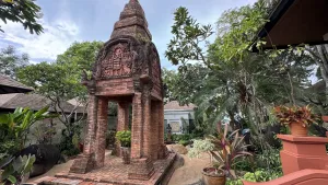 Ancient brick monument surrounded by lush tropical plants.
