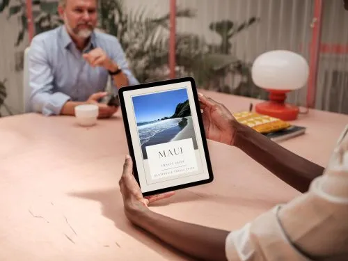 Person viewing Maui travel guide on tablet.